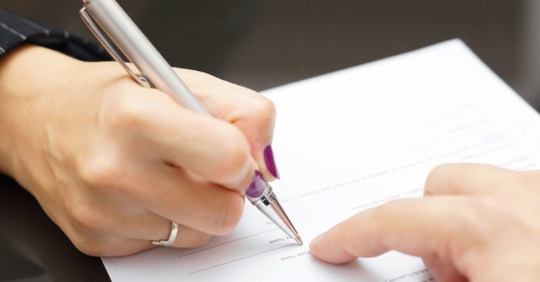 Woman being shown where to sign a prenuptial agreement.