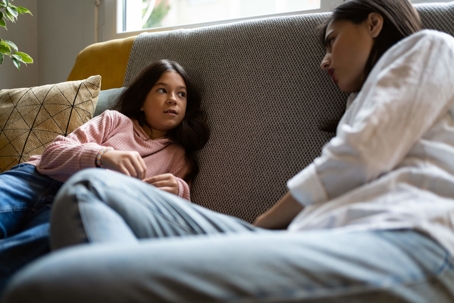 Mom and daughter talking on sofa