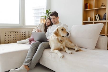 happy couple relaxing at home with their dog