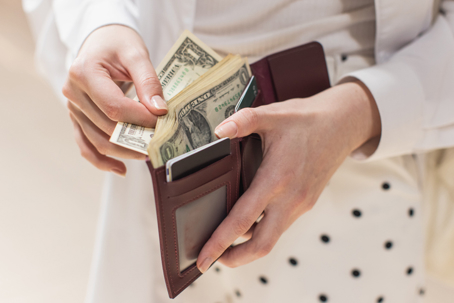 woman counting money in wallet