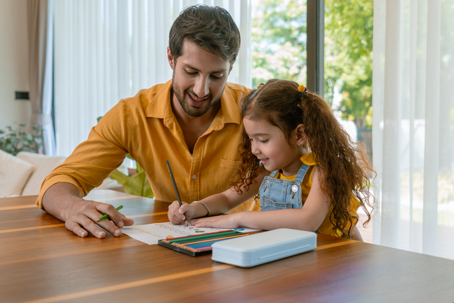father helping daughter color